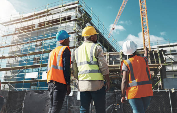 Shot of a group of builders assessing progress at a construction site Shot of a group of builders assessing progress at a construction site